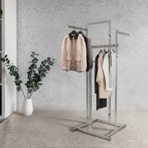 Chrome 4 way garment rack with 16'' straight arms, elegantly displaying various clothes in an aesthetic setting